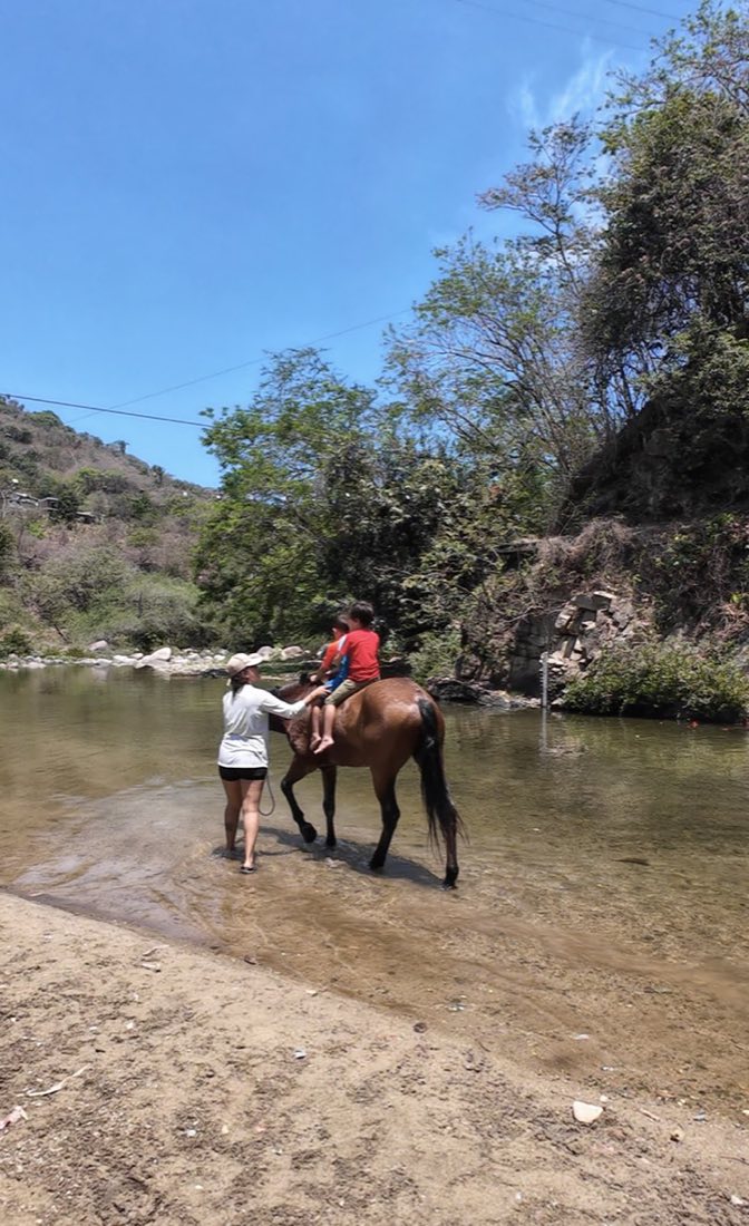 Niños y caballos en la orilla del río, en la sierra de Puerto Vallarta